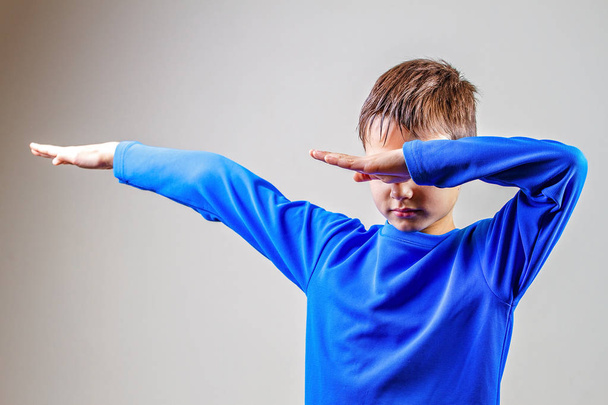 Kid throws dab on the background of a gray wall - Foto, Imagen