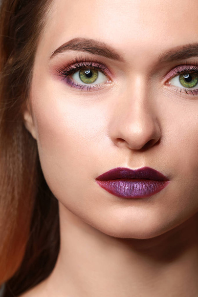 Mujer joven con maquillaje en tonos violeta, primer plano
 - Foto, Imagen