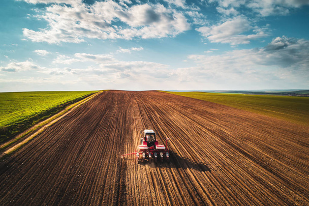 Agriculteur en tracteur préparant des terres agricoles avec lit de semence pour l'année prochaine, vue aérienne
 - Photo, image