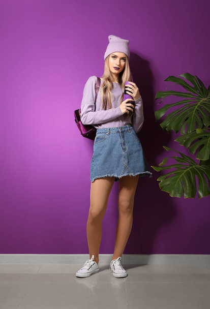 Trendy jonge vrouw in de buurt van violet wand - Foto, afbeelding