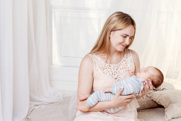 Jolie femme tenant un nouveau-né dans ses bras. Concept de maternité. Concept de famille heureuse
 - Photo, image