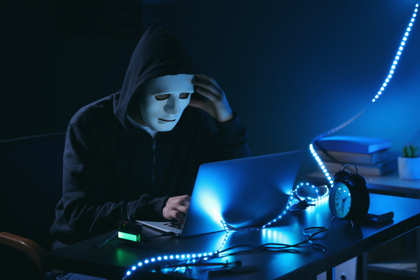 Professional hacker using laptop in dark room - Photo, Image