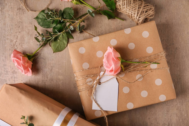 Feestelijke geschenkverpakkingen en bloemen op tafel - Foto, afbeelding
