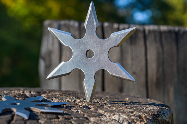 Shuriken (throwing star), traditional japanese ninja cold weapon stuck in wooden background - Photo, Image