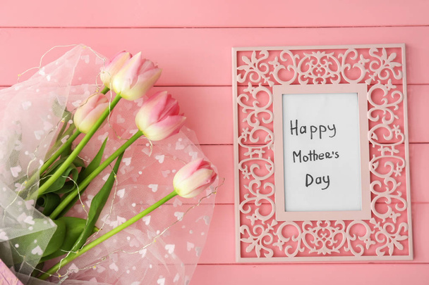 Bouquet of beautiful tulips and frame with text HAPPY MOTHER'S DAY on color wooden background - Photo, Image