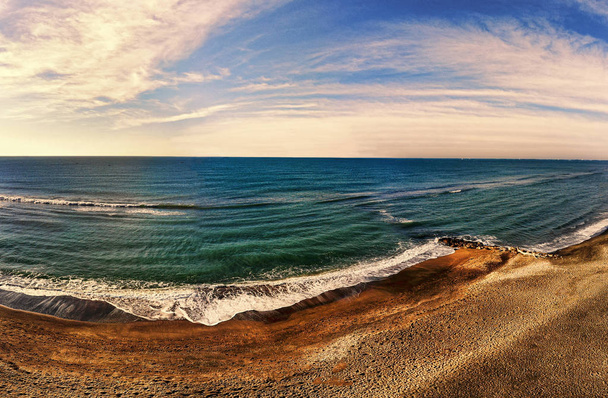 Panorama-view van de zeegezicht boven de oceaan met zand water en schilderachtige hemel - Foto, afbeelding