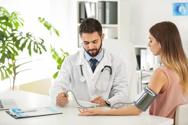 Male doctor working with female patient in clinic - Photo, Image