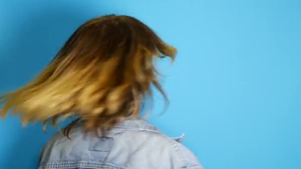 Happy girl with long hair laughing isolated over blue background. Portrait of beautiful surprised and shocked teen girl Emotion, lifestyle - Materiał filmowy, wideo