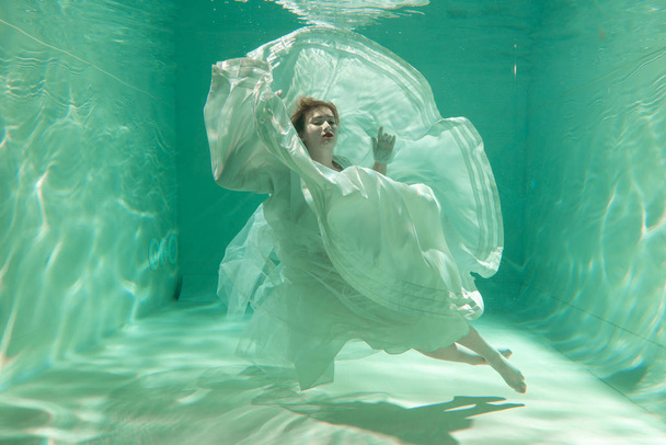 Slim kaukaski kobieta stwarzających w gorącej wody w piękne ubrania tylko w głębokich - Zdjęcie, obraz