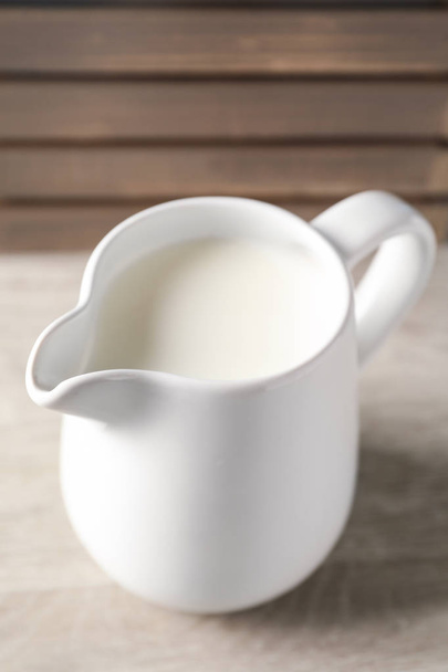Кувшин свежего молока на деревянном столе
 - Фото, изображение