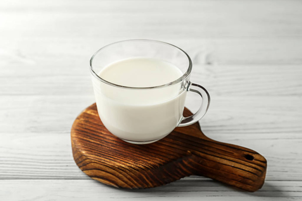 Γυάλινο φλιτζάνι τσαγιού γάλα φρέσκο στο ξύλινο τραπέζι - Φωτογραφία, εικόνα