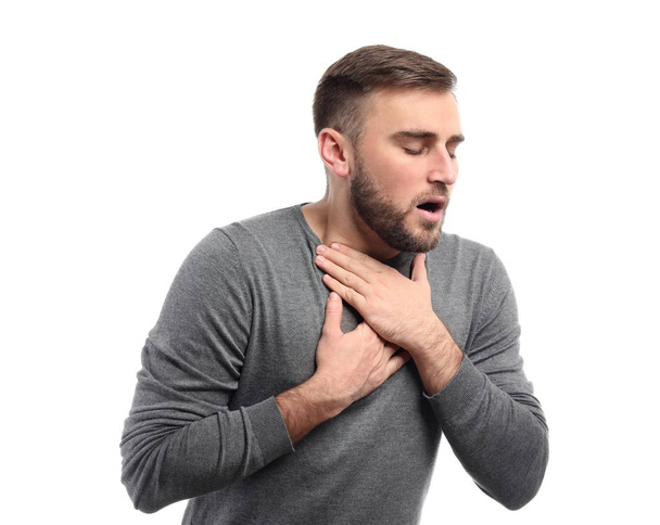 Young man having asthma attack on white background - Photo, image