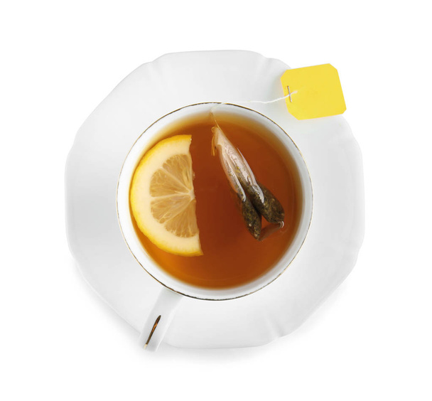 Taza de té caliente con limón sobre fondo blanco - Foto, imagen