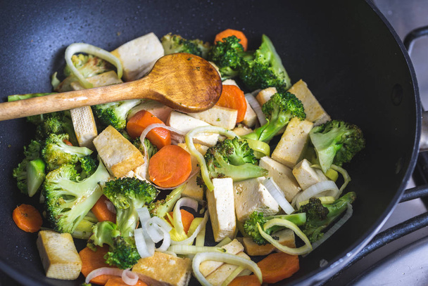 Grilled tofu with broccoli and carrots inside wok. - Foto, imagen