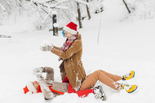 Couple in love lie in the snow, laugh and enjoy - Φωτογραφία, εικόνα