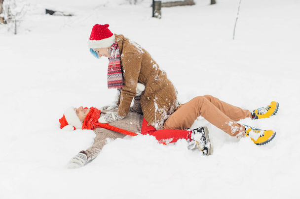 Couple in love lie in the snow, laugh and enjoy - Foto, Bild
