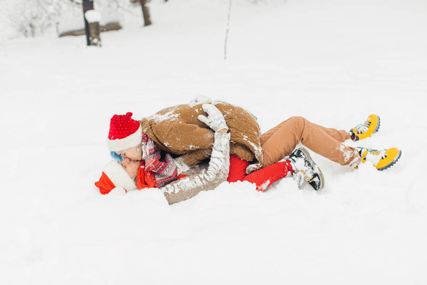 Verliebte Paare liegen im Schnee, lachen und genießen - Foto, Bild