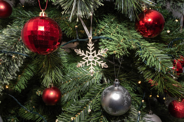 Блестящая рождественская звезда на елке, украшенной качелями и рождественскими огнями
. - Фото, изображение