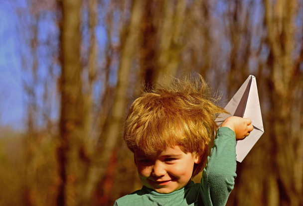 Child play with paper plane toy outdoor. Little child dream of flight. On the waves of my imagination - Φωτογραφία, εικόνα