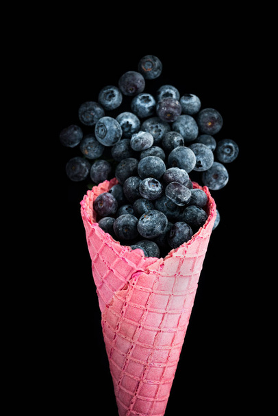 Różowy wafel stożek z owoców mrożonych jagód. Zdrowe lody. - Zdjęcie, obraz