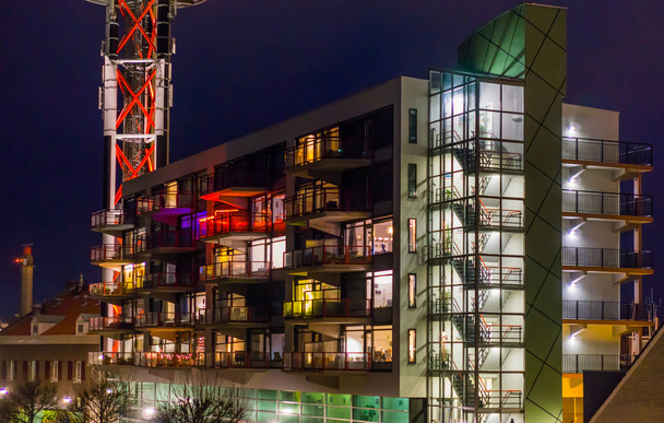 Arquitetura holandesa à noite, prédio de apartamentos iluminado com escadaria e varandas - Foto, Imagem