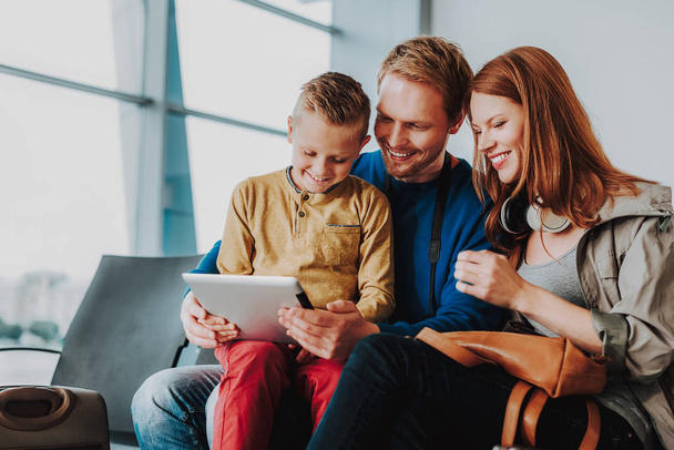 Cheerful family is hanging out with touchpad in lobby - Fotoğraf, Görsel
