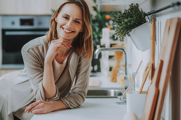 Smiling woman is spending time in kitchen - Photo, image