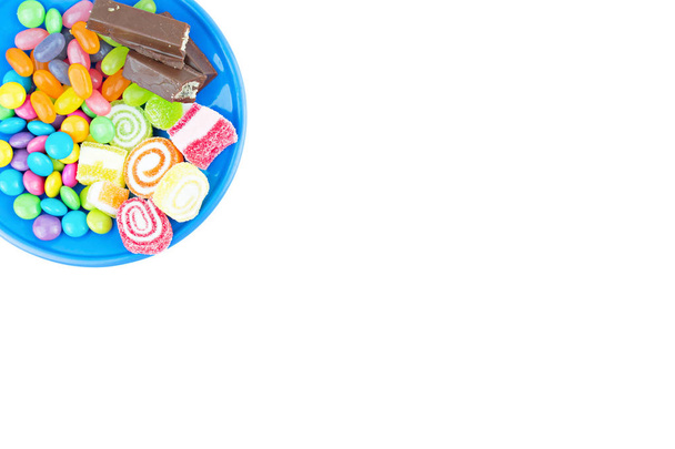 Comidas chatarra como dulces y dulces en un plato aislado en blanco
 - Foto, imagen