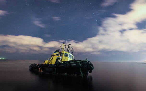 タグボートは、雲に座礁、星降る夜空を走った。長時間露光 - 写真・画像