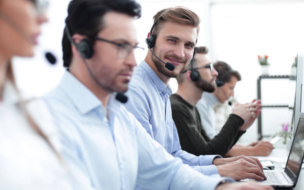 handsome male customer support phone operator with headset working in call center - 写真・画像