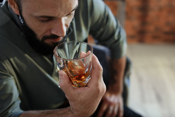 Man with glass of whiskey indoors, closeup - Foto, Imagen