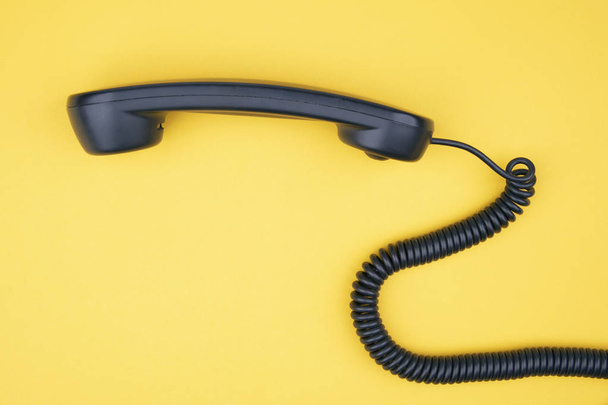 Black telefoon ontvanger op gele achtergrond - Foto, afbeelding