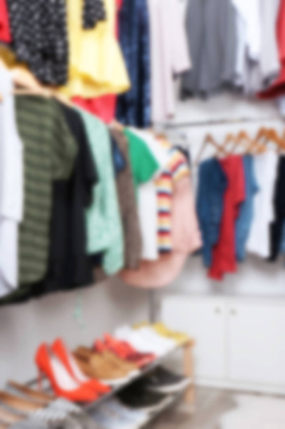 Vista borrosa del vestidor con diferentes ropas y zapatos
 - Foto, Imagen
