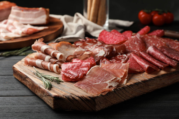 Cutting board with different sliced meat products served on table - Zdjęcie, obraz
