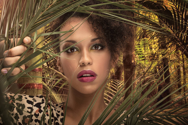 African american beautiful woman posing in the green jungle. Closeup beauty portrait. - Fotografie, Obrázek