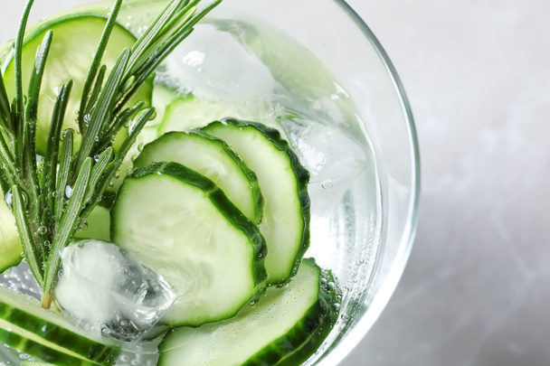 Glass of fresh cucumber water on light background, top view - Photo, Image