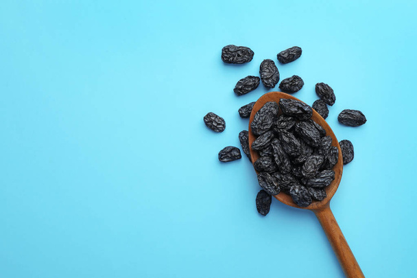 Spoon of raisins on color background, top view with space for text. Dried fruit as healthy snack - Foto, immagini