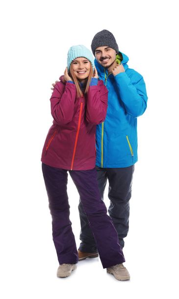 Young couple wearing warm clothes on white background. Ready for winter vacation - Valokuva, kuva