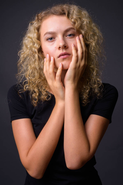 Portret van jonge mooie vrouw met krullend blond haar - Foto, afbeelding