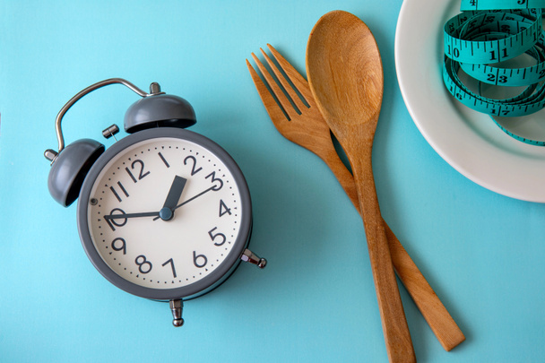 Tijd om gewicht te verliezen, eetcontrole of tijd om dieet concept, wekker met gezonde tool concept decoratie op blauwe achtergrond - Foto, afbeelding