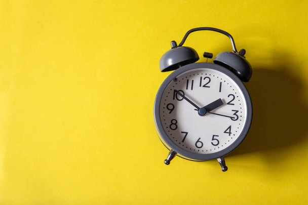 明るい黄色の背景で時間管理概念の目覚まし時計 - 写真・画像