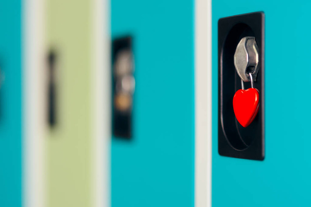 Close-up of a Heart Shaped Padlock Keeping Locker Closed - Фото, зображення