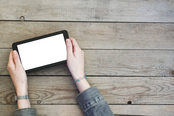 Femme mains tenant tablette numérique avec écran blanc sur une table en bois
. - Photo, image