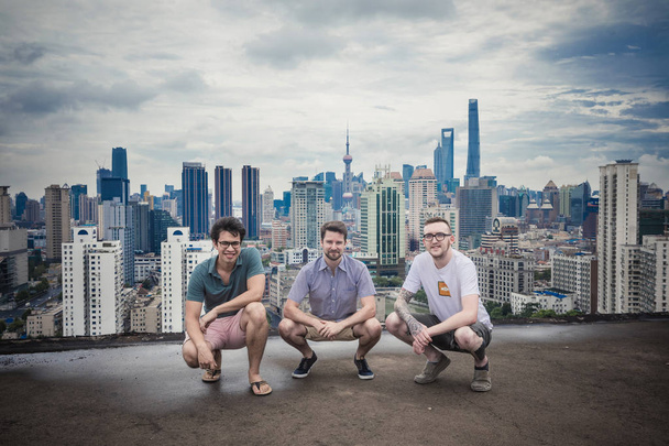(Da sinistra) uomini americani Charlie Erickson, Jay Thornhill e Tyler McNew creando un sito di e-commerce chiamato Baopals, che naviga Taobao di Alibaba e Tmall in traduzione inglese, sono visti sul tetto di un edificio contro lo skyline di th
 - Foto, immagini