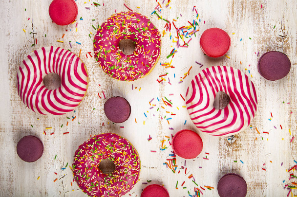 Donuts and macaroons on a wooden background. Delicious dessert. - Fotoğraf, Görsel
