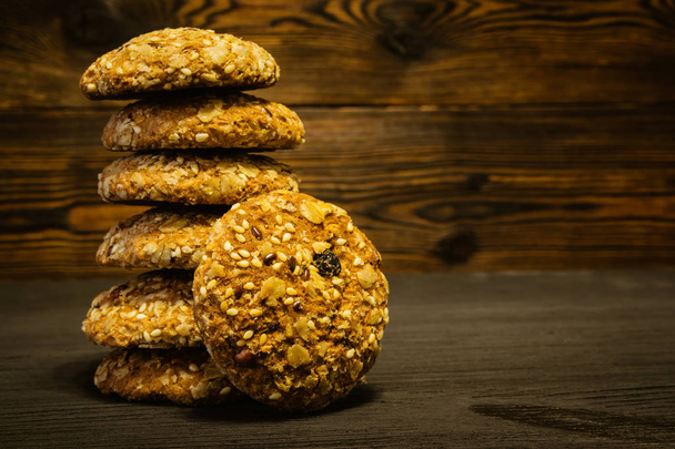 Oatmeal cookies laid pile on wooden background - Fotoğraf, Görsel