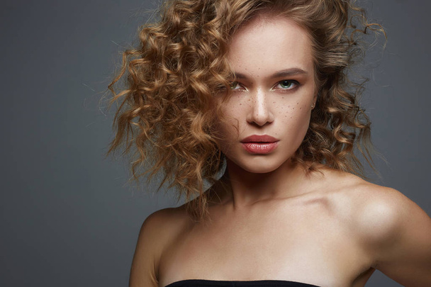 Beautiful freckles woman face. amazing curly girl with make-up. beauty fashion portrait. frizzle hair - 写真・画像
