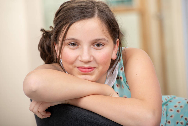 Portret van een mooie jonge tiener meisje zittend op fauteuil - Foto, afbeelding