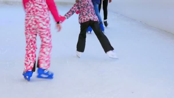 Kinderen schaatsen op kunstmatige overdekte ijsbaan. Close-up op de schaats op pootjes bewegen rond in cirkels. - Video