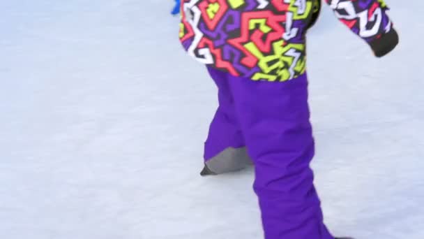 Nahaufnahme von Kindern, die auf einer Kunsteisbahn Schlittschuhlaufen lernen. Nahaufnahme auf Schlittschuhen auf Füßen, die sich im Kreis bewegen. - Filmmaterial, Video